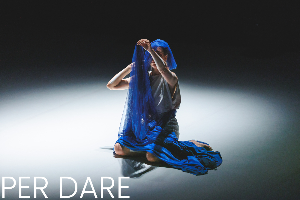 Une femme avec un voile bleu sur la tête dans une posture énigmatique